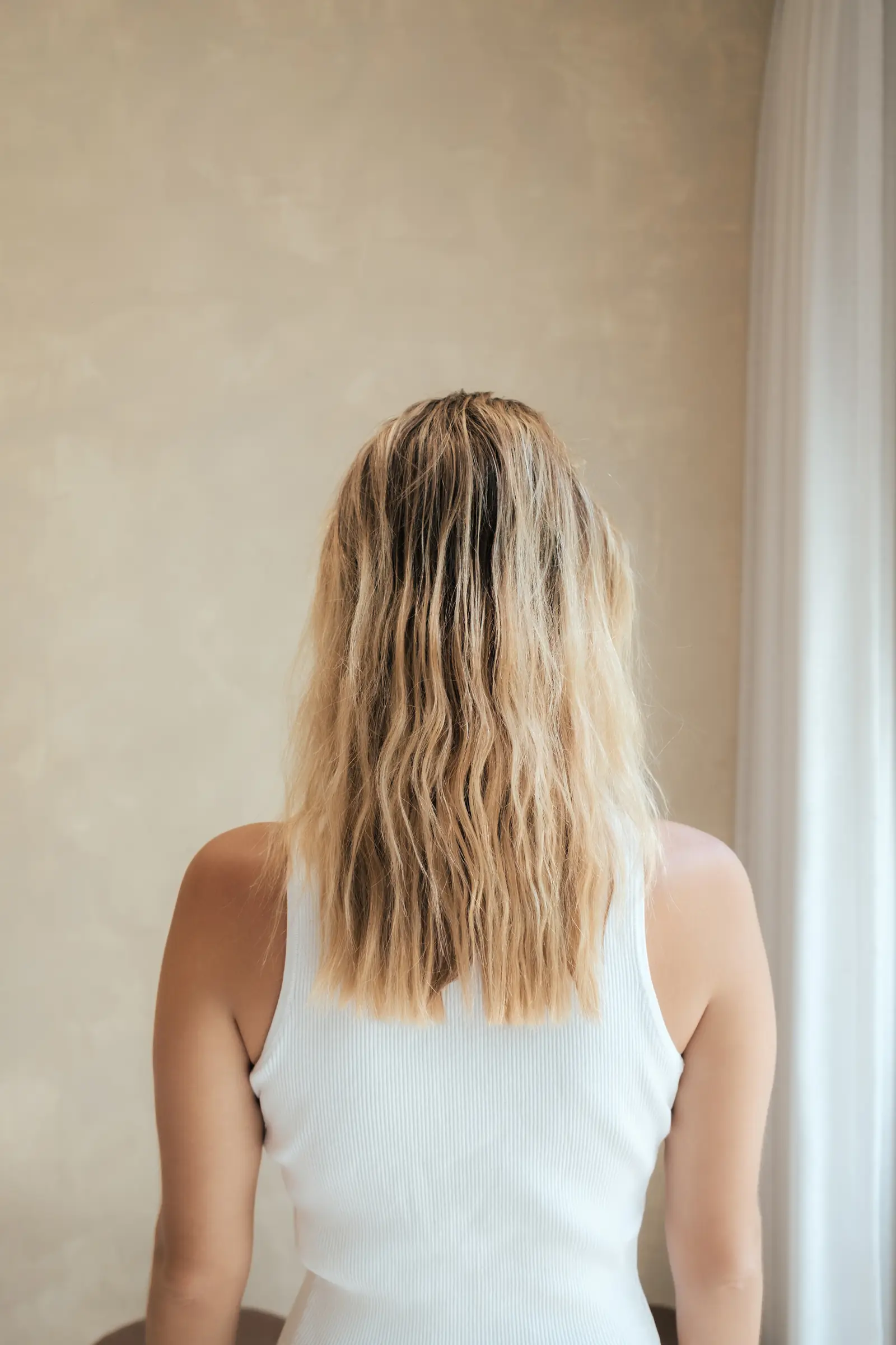 Blonde hair before the full bleach, roots grown out and the lengths uneven