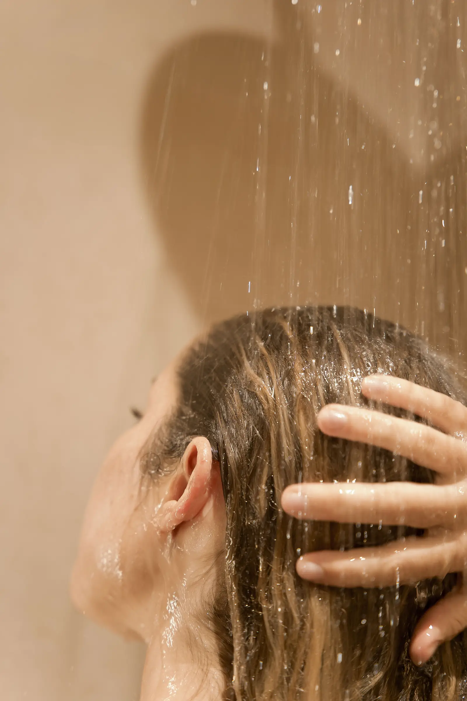 A guest washing her blonde hair in the shower at Day Hair Habit