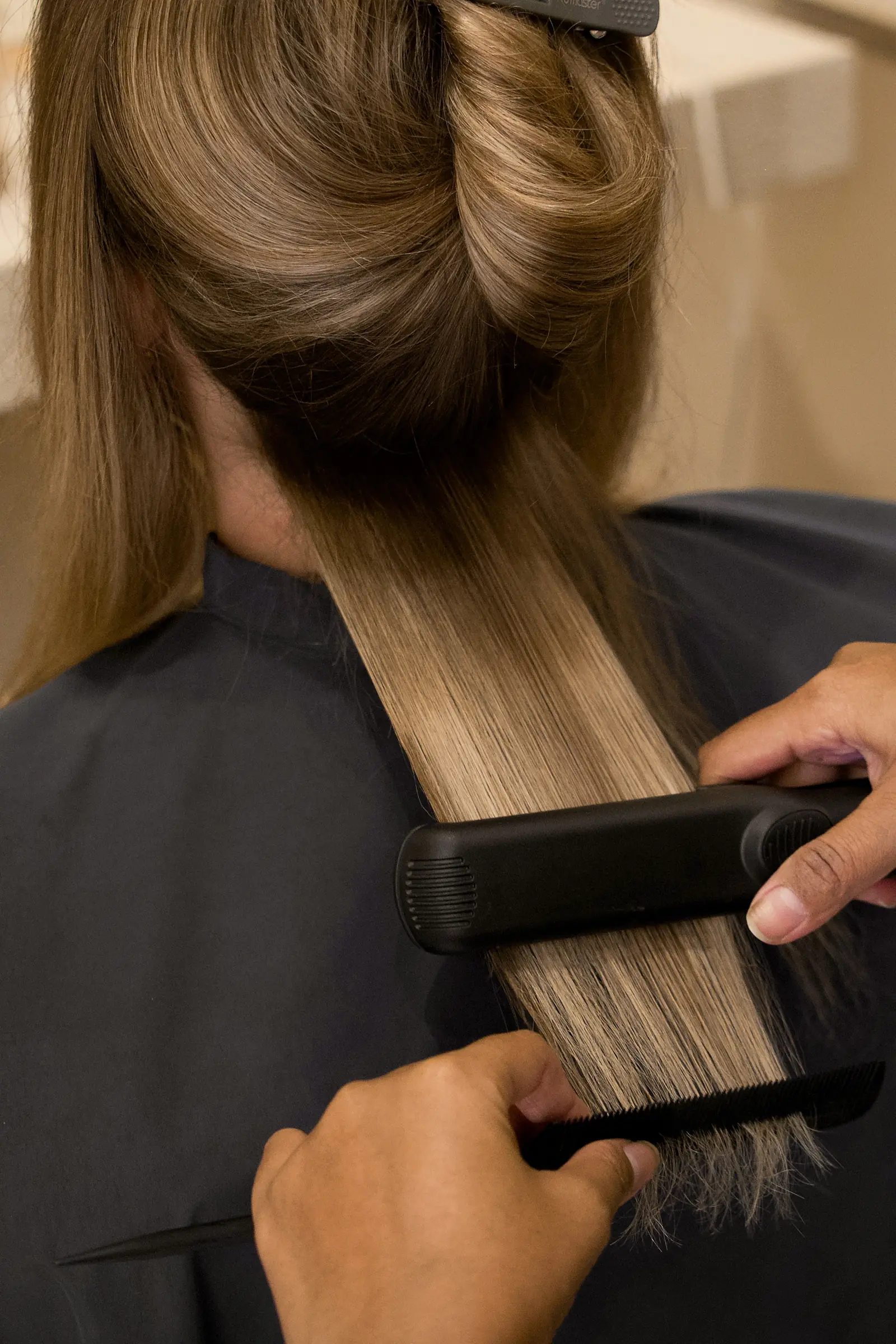 A flat iron sealing a keratin treatment into long hair at Day Hair Habit