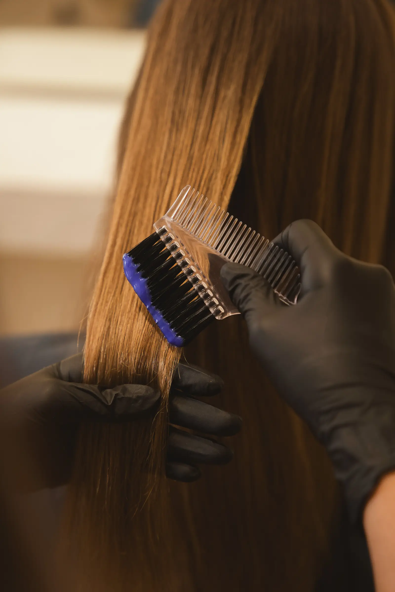 Keratin smoothing treatment brushed evenly through a guest's hair at Day Hair Habit