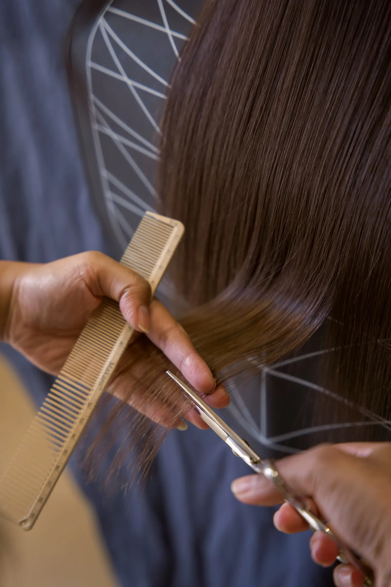 A stylist measuring the ends before cutting